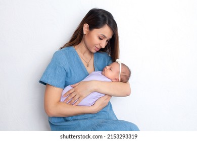 Beautiful young mother with a newborn daughter in a diaper on a white background. Motherhood. Tenderness. Space for text. High quality photo - Shutterstock ID 2153293319
