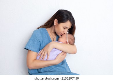 Beautiful young mother with a newborn daughter in a diaper on a white background. Motherhood. Tenderness. Space for text. High quality photo
