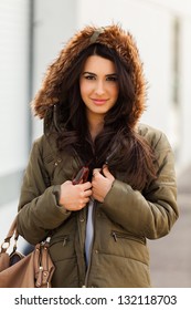 Beautiful young multicultural woman outdoors wearing a winter fur coat.