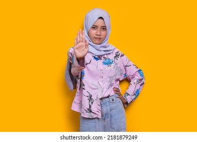 Beautiful Young Muslim Woman Hand Doing Stop Sign With Serious Expression Defense Gesture Isolated On Yellow Background
