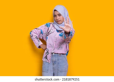 Beautiful Young Muslim Woman Hand Doing Stop Sign With Serious Expression Defense Gesture Isolated On Yellow Background
