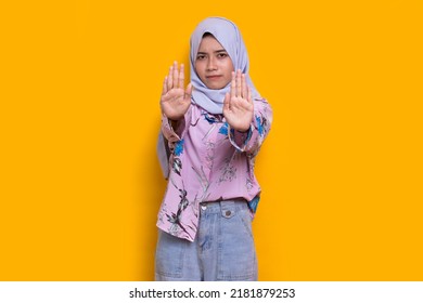 Beautiful Young Muslim Woman Hand Doing Stop Sign With Serious Expression Defense Gesture Isolated On Yellow Background
