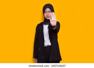 Beautiful Young Muslim Woman Hand Doing Stop Sign With Serious Expression Defense Gesture Isolated On Yellow Background
