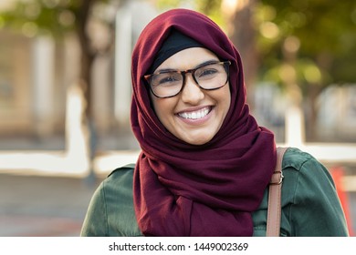 Beautiful young muslim woman wearing hijab and spectacles. Islamic curvy woman looking at camera. Closeup face of arabic girl wearing eyeglasses and looking at camera with a big grin.