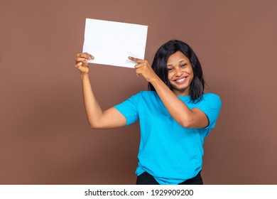 beautiful young nigerian lady holding up an empty sign while feeling excited, advertising concept