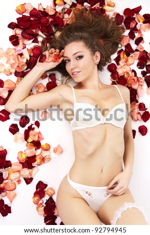 Hispanic Woman Laying On Massage Table Covered In Rose 