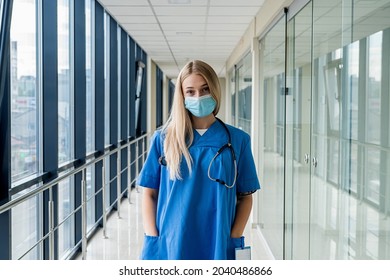 Beautiful Young Nurse In A Mask Stands In The Hallway