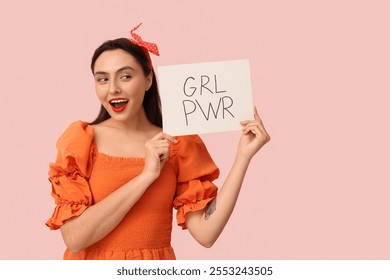 Beautiful young pin-up woman holding paper with text GRL PWR on pink background - Powered by Shutterstock