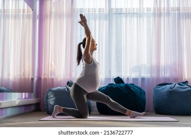 Beautiful young pregnant woman is engaged in pilates. The expectant mother plays sports while waiting for the birth of a child.