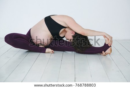 Beautiful young pregnant woman practicing yoga on a wooden white floor in a bright studio.Care of health and pregnancy.
Yoga for pregnant woman. People, lifestyle, leisure and relaxation

