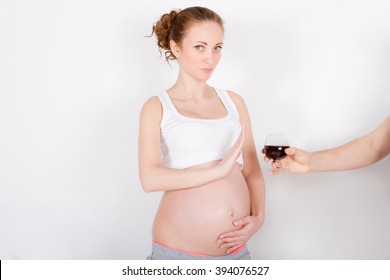 Beautiful young pregnant woman / teenager refuses to drink a wine