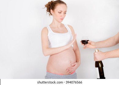 Beautiful young pregnant woman / teenager refuses to drink a wine