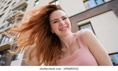 Beautiful Young Red-haired Woman With Braces On Her Teeth Smiling In The Summer Outdoors