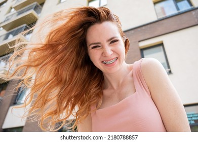 Beautiful Young Red-haired Woman With Braces On Her Teeth Smiling In The Summer Outdoors