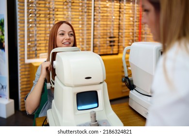 Beautiful Young Redhead Woman Is Smiling During Eyesight Diopter Examination And Checkup At Eye Specialist Clinic Or Optical Store.