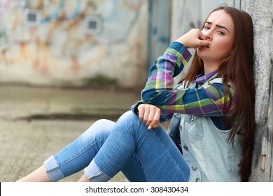 Beautiful Young Sad Girl Sitting On Asphalt