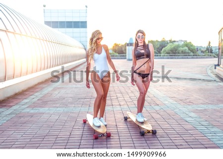 Similar – Image, Stock Photo Two women holding surfboard and looking at camera