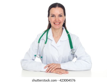 Beautiful Young Smiling Female Doctor Sitting At The Desk. Isolated On White