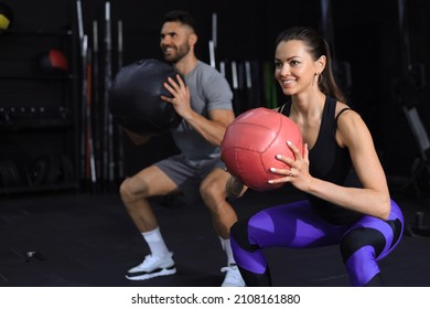 Beautiful young sports couple is working out with medicine ball in gym - Powered by Shutterstock