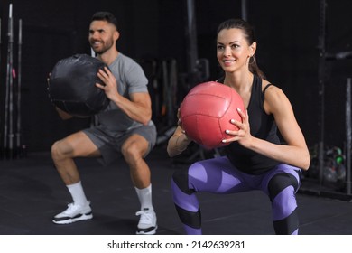 Beautiful young sports couple is working out with medicine ball in gym - Powered by Shutterstock