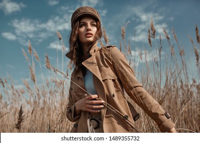 Beautiful Young Stylish Girl in Trench Coat Walking Autumn or Spring street. Autumn outdoor fashion. 