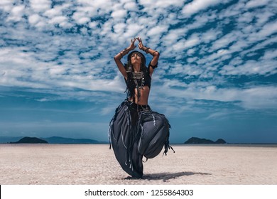 Beautiful young stylish tribal dancer. Woman in oriental costume dancing outdoors
