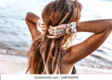 beautiful young stylish woman on the beach at sunset