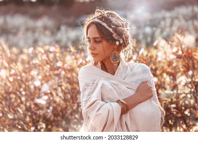 beautiful young stylish woman posing on the field at sunset portrait