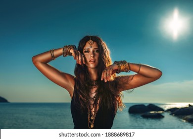 beautiful young stylish woman at sunset at the beach