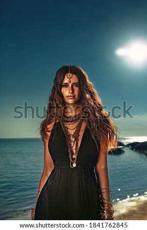 beautiful young stylish woman at sunset at the beach