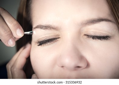 Beautiful young teen girl getting eyebrow plucked. closeup