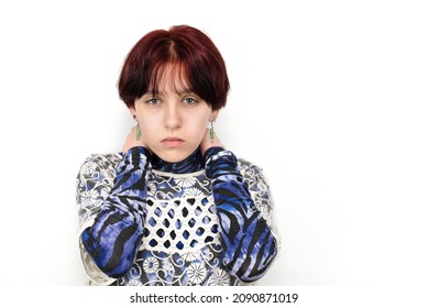 Beautiful Young Teen Girl With Short Red Dyed Hair On A Light Background, Sad Girl Hugging Herself. A Teenage Girl Has Problems Communicating With Others. Copy Space