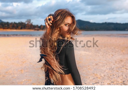 beautiful young tribal style woman on the beach at sunset