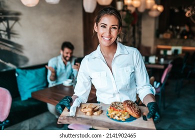 Beautiful young waitress serving delicious burger to middle age male customer.  - Powered by Shutterstock