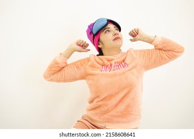 Beautiful Young White Asian Woman Wearing A Pink Pajamas, Night Cap And Sleep Mask, Waking Up From Her Sleep, On White Background