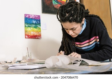 Beautiful Young White Hispanic Latin Art Director Girl With Dreadlocks, Concentrating On A Cinematic Mock-up With Styrofoam And Paper Sheets In Her Design Workshop