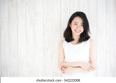 beautiful young woman against white wooden wall