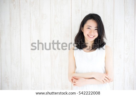 beautiful young woman against white wooden wall