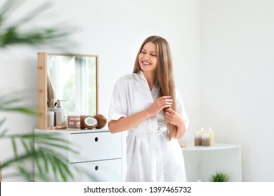 Beautiful Young Woman Applying Coconut Oil On Hair At Home