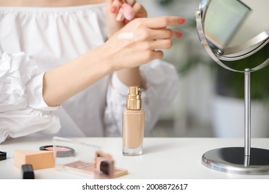 Beautiful Young Woman Applying Foundation At Home