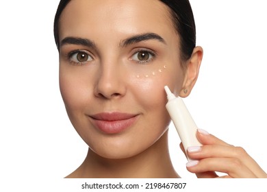 Beautiful Young Woman Applying Gel On Skin Under Eye Against White Background