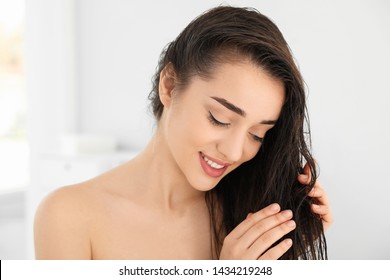 Beautiful young woman applying hair conditioner in bathroom - Shutterstock ID 1434219248