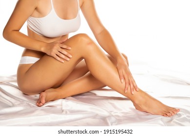 Beautiful Young Woman Applying Lotion On Her Legs, Isolated On White. 