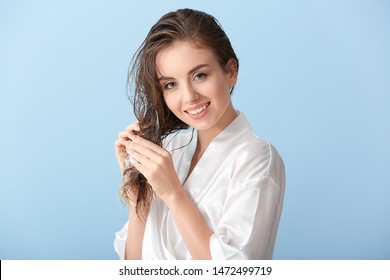 Beautiful Young Woman Applying Mousse On Her Hair After Washing Against Color Background