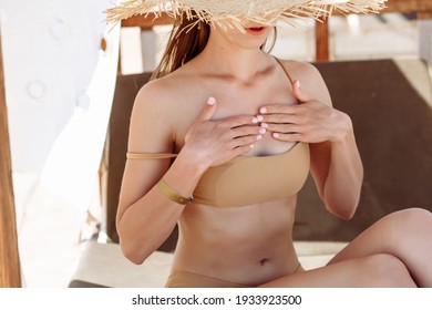 Beautiful young woman applying suntan lotion at sea with copy space. Tanned girl in bikini applying sunscreen on shoulder at tropical beach. Woman protecting skin with sunblock cream from UV. - Powered by Shutterstock