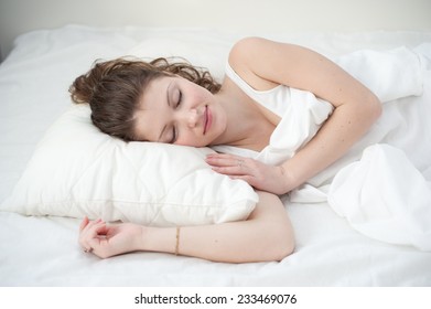 Beautiful young woman asleep, on white background