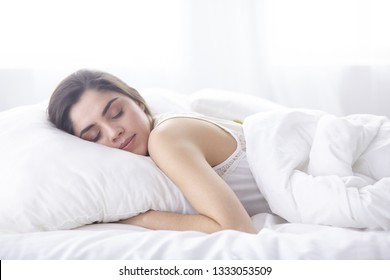 schöne junge Frau, die morgens im Bett liegt. Schönes Model-Gesicht sieht sexy in der Kamera aus