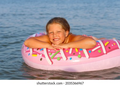 Beautiful Young Woman Bathing With Colorful Inflatable Donut Rubber Ring At Sea Ocean Resort