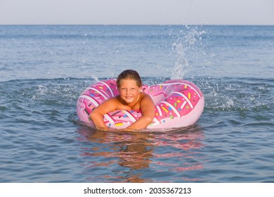 Beautiful Young Woman Bathing With Colorful Inflatable Donut Rubber Ring At Sea Ocean Resort