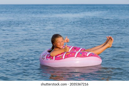 Beautiful Young Woman Bathing With Colorful Inflatable Donut Rubber Ring At Sea Ocean Resort